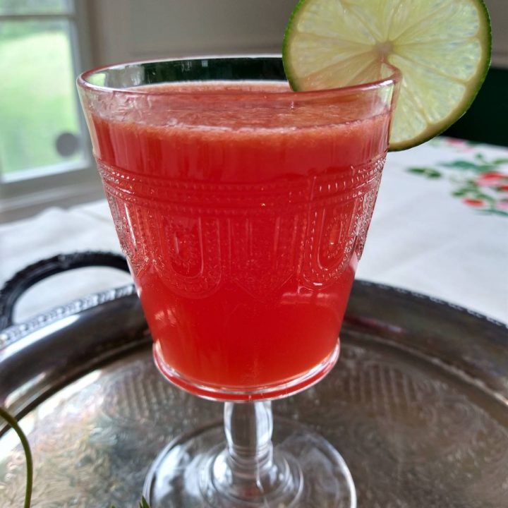 fresh strawberry punch in a glass with a lime garnish
