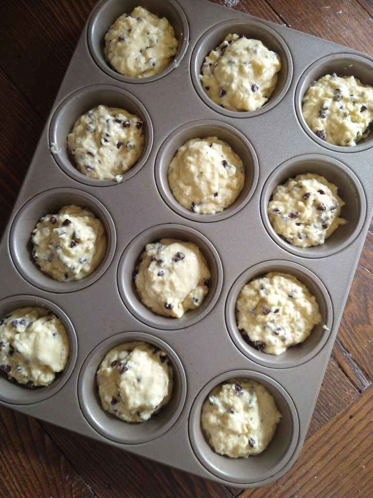 chocolate chip muffin batter in muffin tin cups
