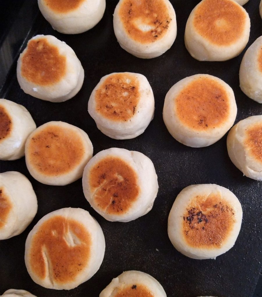 mini rolls cooking on a black griddle