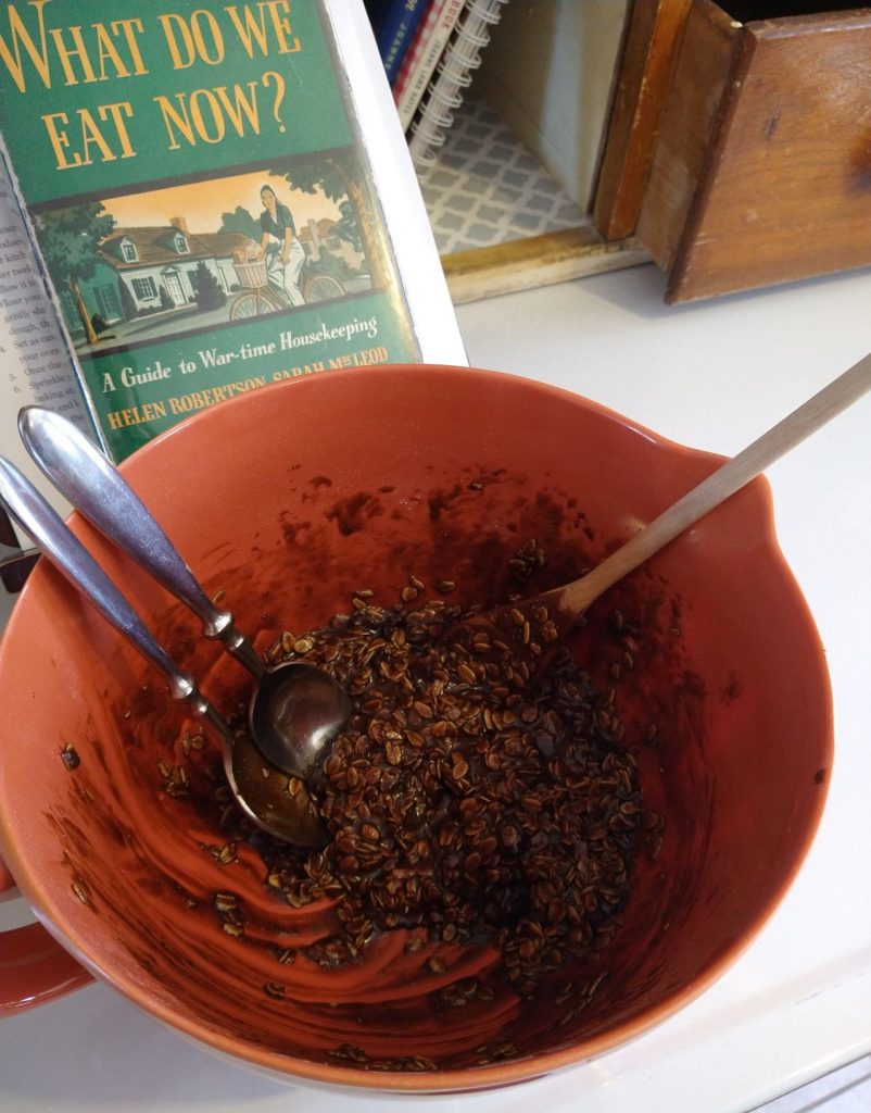 mixing bowl with cookie dough and spoons with cookbooks in background