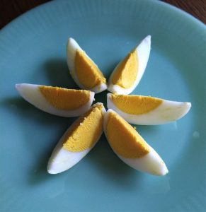 six boiled egg wedges arranged in a star shape on a glass plate