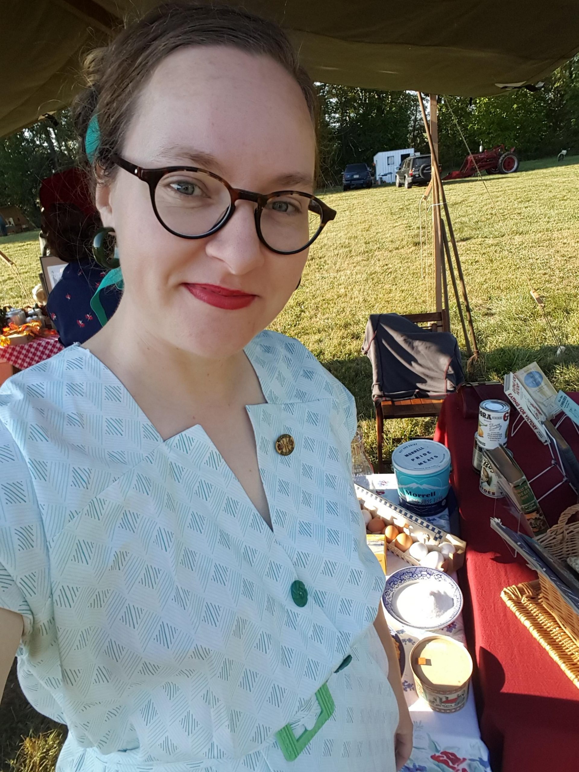Sarah in 1940s dress under a tent outside