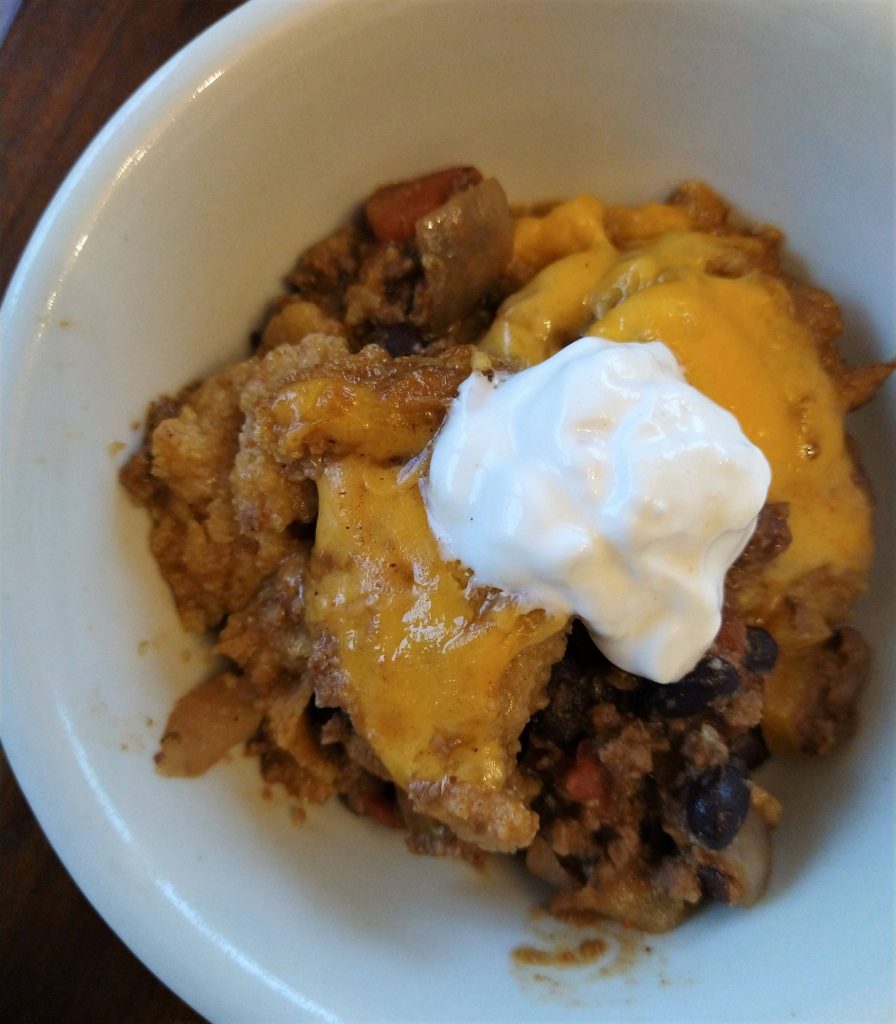 tamale pie special casserole with cheese and sour cream in a white bowl