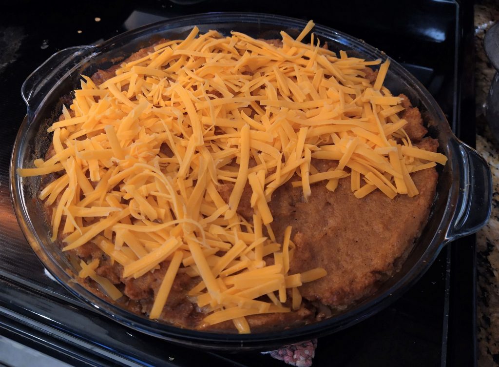 casserole in a glass dish topped with shredded cheese