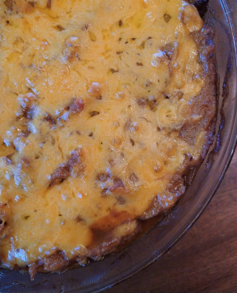 close up of a casserole in a glass dish with melted cheese