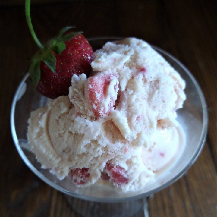 strawberry ice cream in glass garnished with fresh strawberry