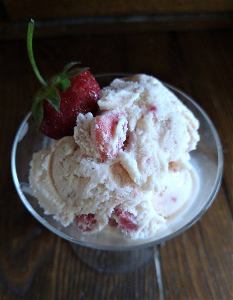 strawberry ice cream in a glass with fresh strawberry as garnish