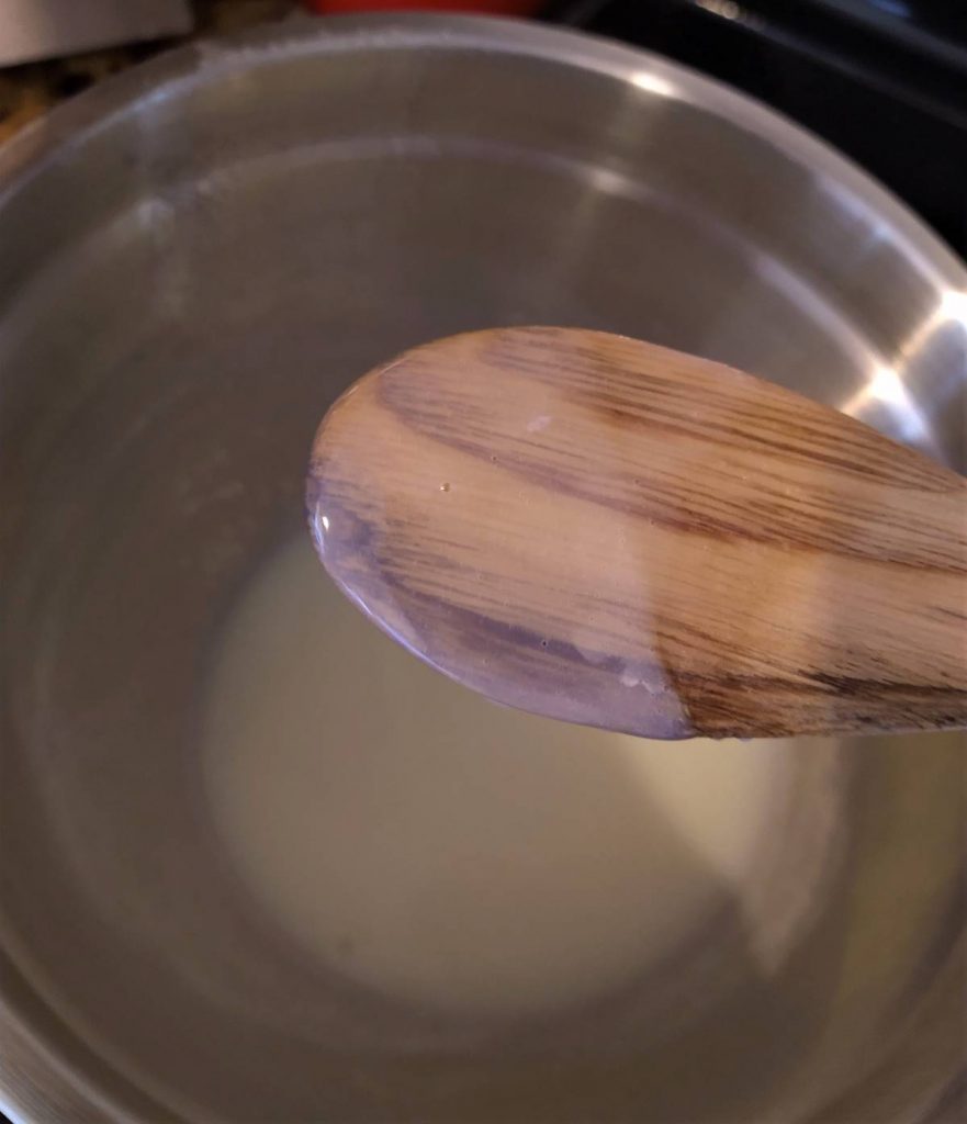wooden spoon coated with white custard mixture