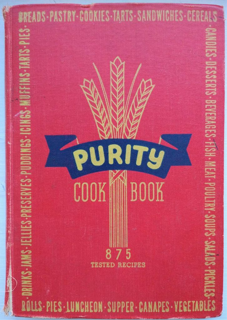 red cover for Canadian Purity Cook Book featuring three wheat stalks and a blue banner with the word purity on it